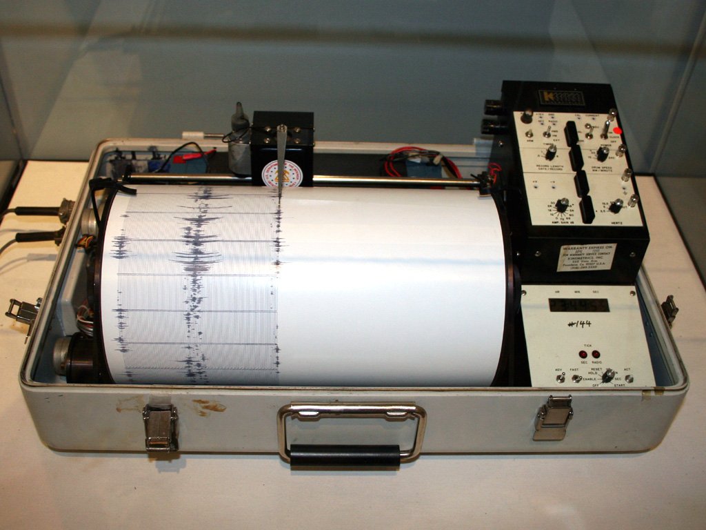 Sismógrafo Kinemetrics con tambor giratorio y papel con registro de ondas sísmicas