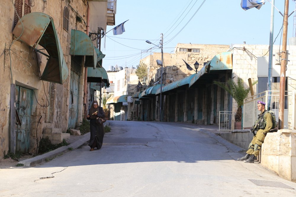 Calle en Hebrón, Cisjordania, con un puesto de control