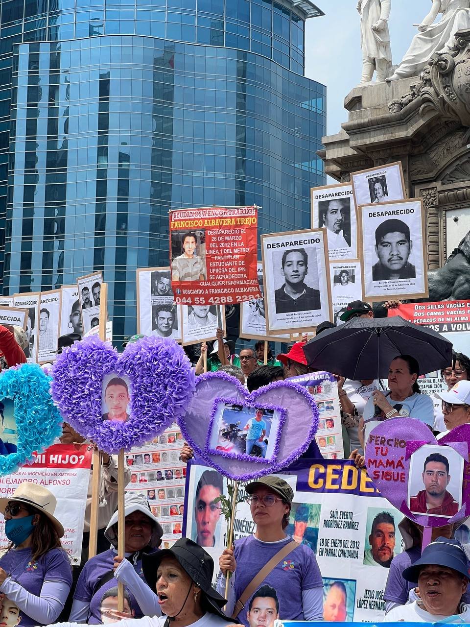 Madres buscadoras marchan por el Paseo de la Reforma en la Ciudad de México durante la Marcha de la Dignidad Nacional, con fotografías de sus hijos e hijas desaparecidos.